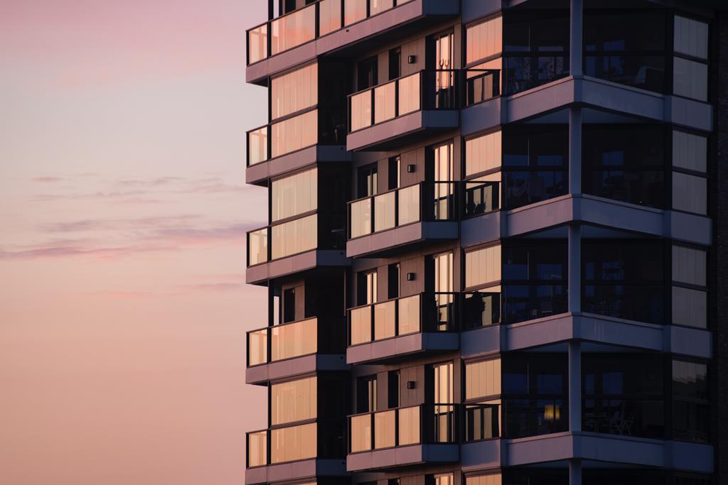 fachada um prédio no por do sol com janelas e sacadas de apartamentos