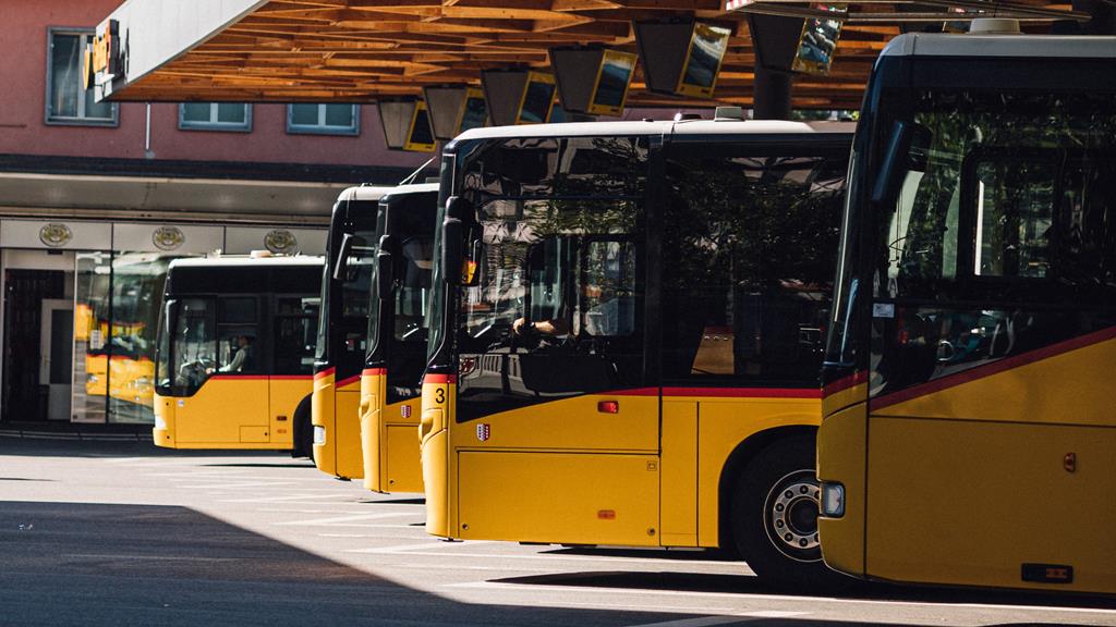 Terminal de ônibus com vários ônibus amarelos e pretos estacionados