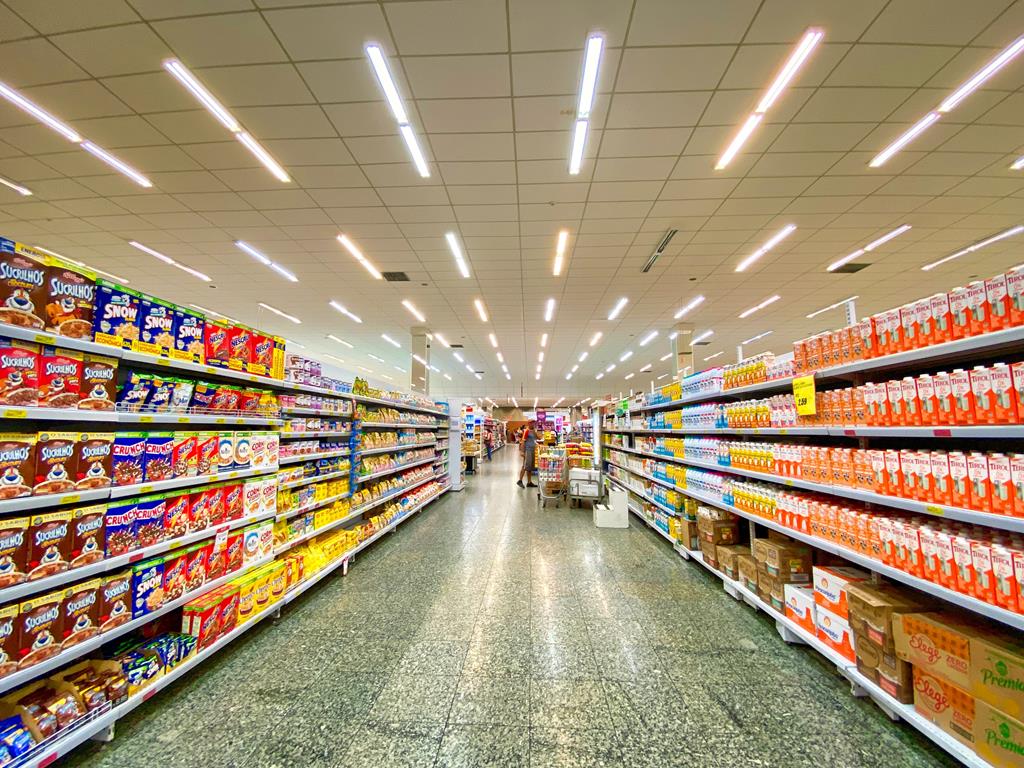 corredor de supermercado com prateleiras de cereais matinais e leites